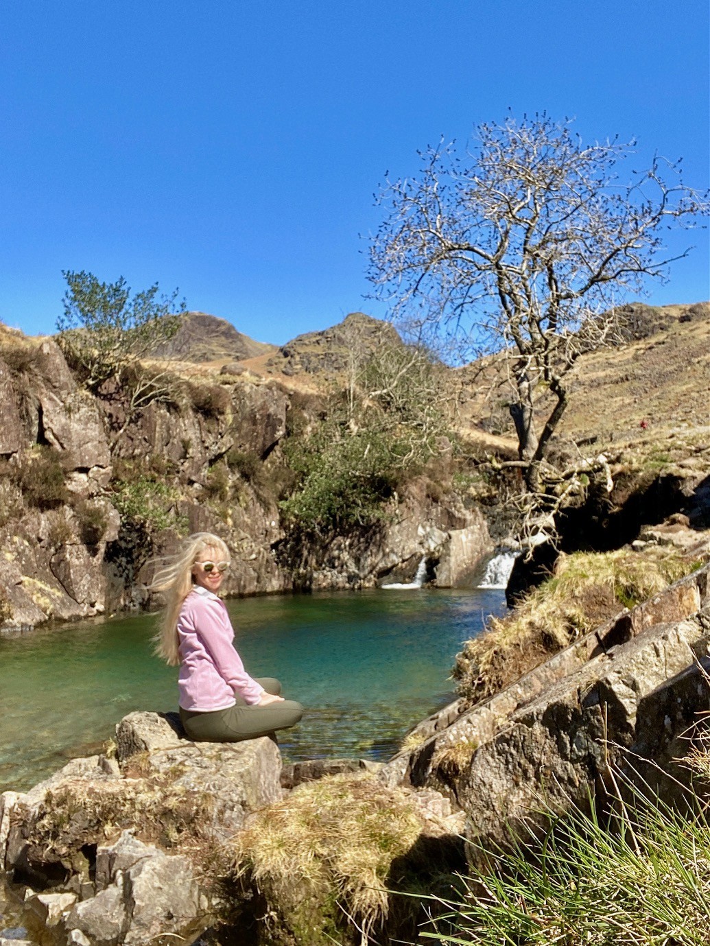 A woman sitting by Tongue Pot, at Esk Falls in the Lake District.