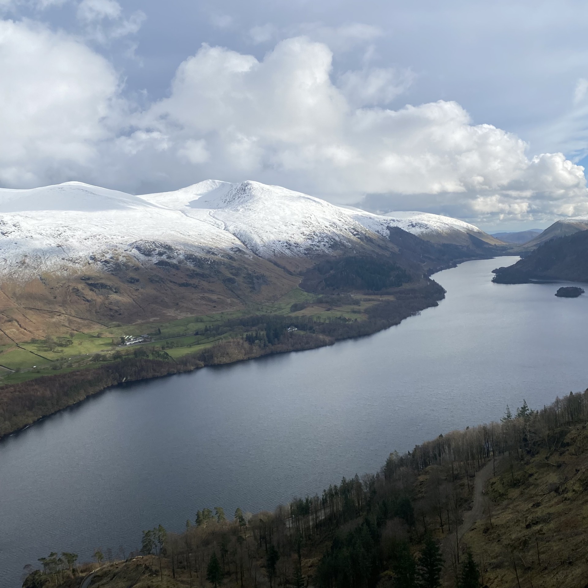 A view of Thirlmere and snow capped mountains in the distance
