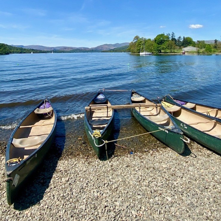 Rowboats on a pebble beach on the shore of Lake Windermere.